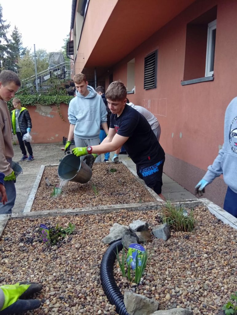 Uczniowie pracujący nad ogrodem deszczowym